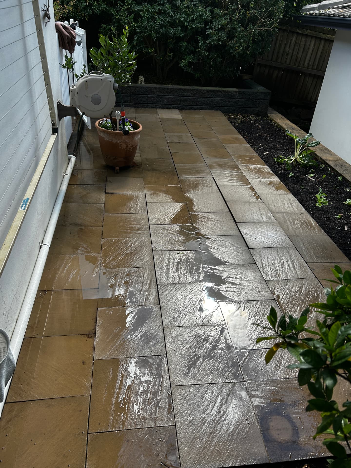 The same sandstone patio washed back to its natural warm tone by True Clean Pressure Washing