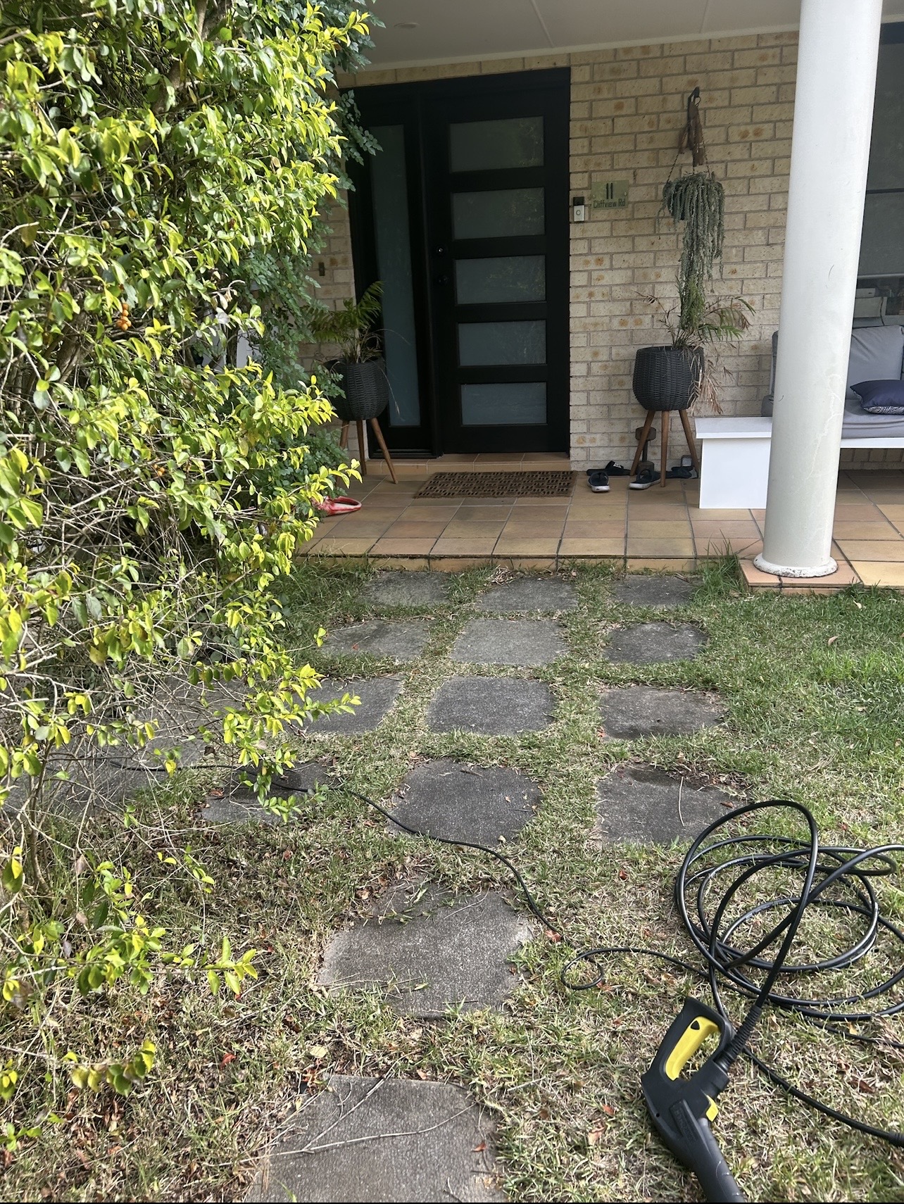 Stepping stone path and pavers dulled with dirt and growth before pressure washing